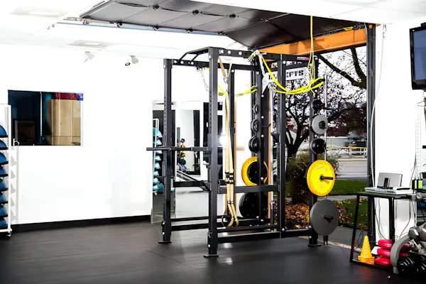 Squat rack in the back room with the garage door open for fresh air.