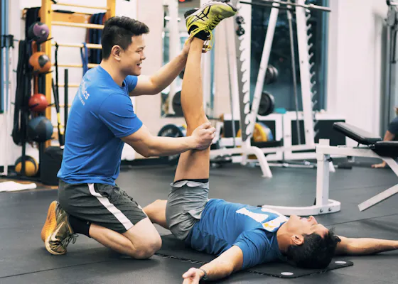 Nathan stretching client on a mat.